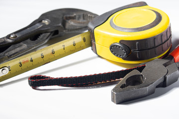 pliers wrench and tape measure on white background isolated