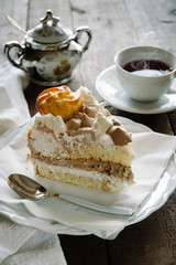 Cream cake decorated with cream puffs filled with cream and chocolate.