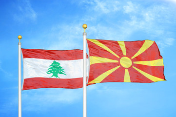 Lebanon and North Macedonia two flags on flagpoles and blue cloudy sky
