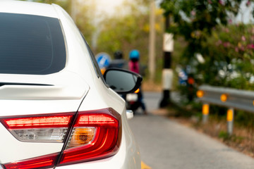 White luxury cars, brakes on the roads at the intersection with blurry images of motorcyclists in the front.