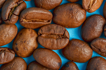 Coffee beans on a blue background macro closeup