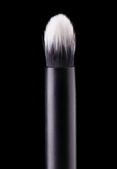 Cosmetic makeup eyeshadow brush isolated on a black background