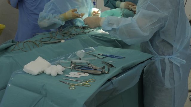 The surgeon in the operating room takes a thread to sew up the wound. surgical instruments on the table. Coronavirus in the hospital. surgery on the lungs. covid-19