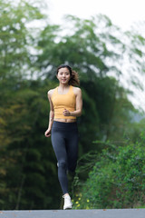 A young Asian woman is running
