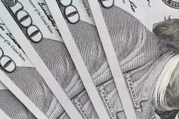 close up of several fan-shaped one hundred US dollars banknotes