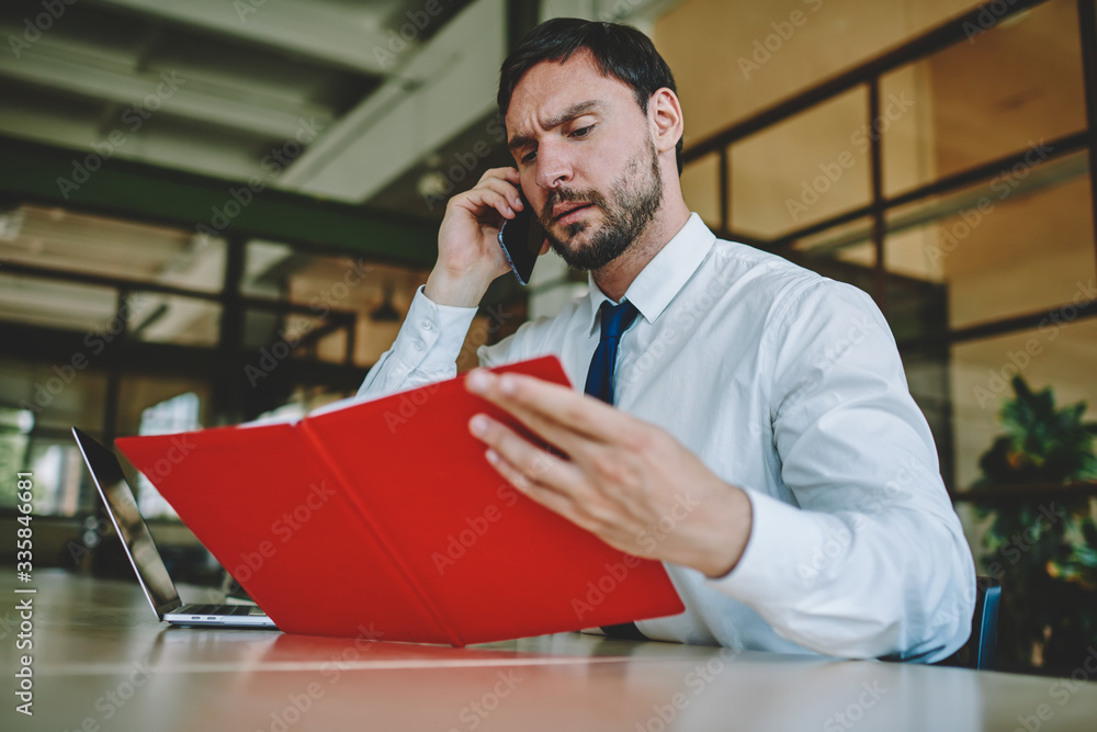 Aufkleber puzzled marketing expert learning account numbers from notepad during smartphone communication in mo