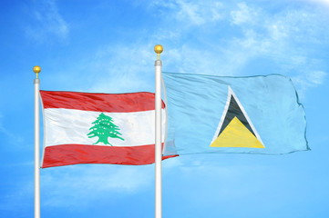 Lebanon and Saint Lucia two flags on flagpoles and blue cloudy sky