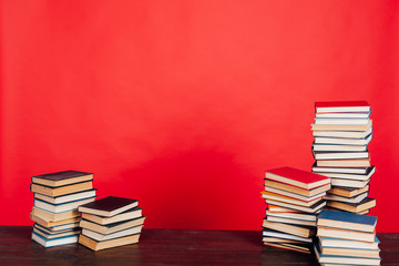 many stacks of educational books for learning the preparation for exams on a red background