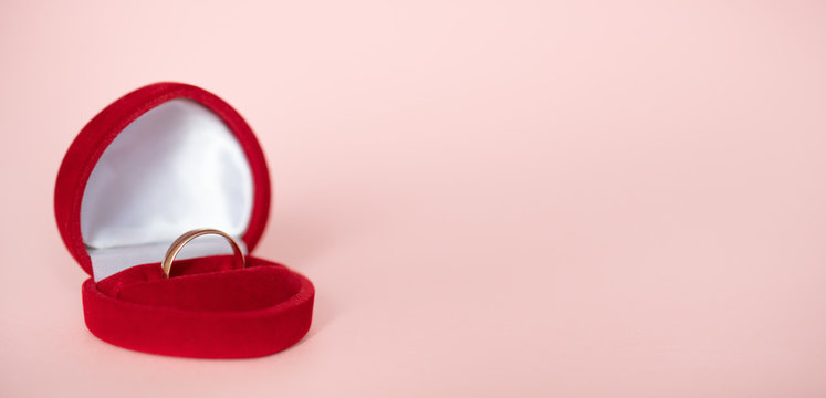 Open Red Gift Box In The Form Of A Heart With A Gold Wedding Ring Inside Lies On A Pink Background, Front View: Wedding Concept, Valentine's Day