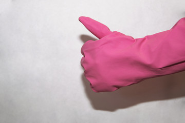 Pink household glove on hand shows super on a white background for cleaning