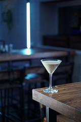 White creamy alcoholic cocktail in martini glass in a loft bar