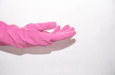 Pink household glove dressed on the right hand on a white background