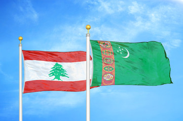 Lebanon and Turkmenistan two flags on flagpoles and blue cloudy sky