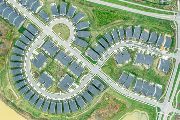 Aerial view of the geometrical curving American residential neighborhood, single family homes built close to each other by a cross street in Two Rivers Crofton Maryland