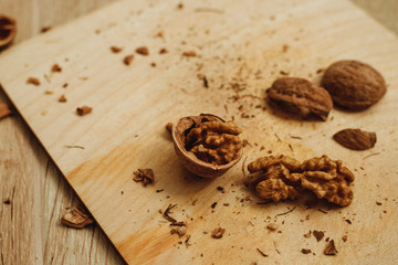 Walnuts, broken shells. Nut kernels on a wooden Board. Close up. Background or texture.