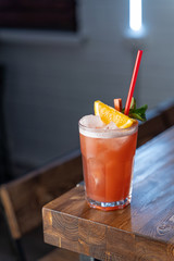 Zombie cocktail based on rum and grapefruit juice on a wooden table in a modern bar