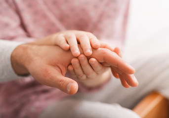 Close up of kid holding father palm with two hands