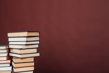 many stacks of educational books for learning the preparation for exams on a brown background