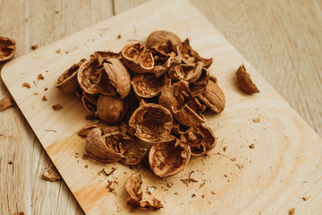 Walnuts, broken shells. Nut kernels on a wooden Board. Close up. Background or texture.