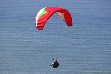 Paraglider flying above the sea	