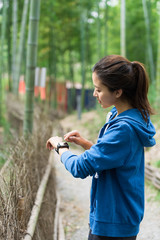 A young Asian woman walks and rests in a bamboo forest