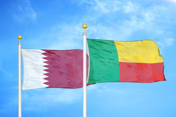 Qatar and Benin  two flags on flagpoles and blue cloudy sky