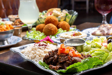 A view of a table full of several Mediterranean dishes, in a restaurant or kitchen setting.