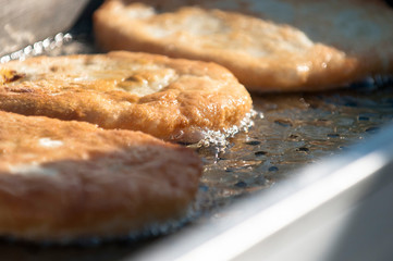 Pies with meat fried in boiling sunflower oil. Top view.