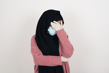 Indoor portrait of beautiful muslim  woman with stylish haircut, wearing casual clothes, making...