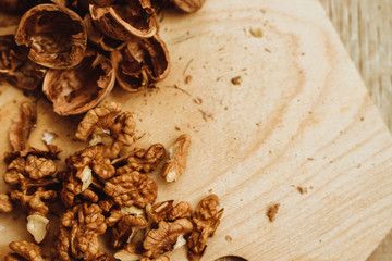 Walnuts, broken shells. Nut kernels on a wooden Board. Close up. Background or texture.