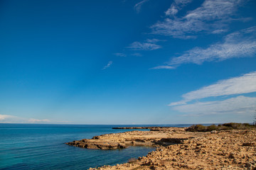 ocean shore made of stones, blue sky