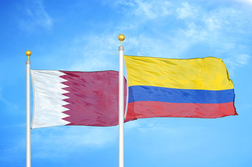 Qatar and Colombia two flags on flagpoles and blue cloudy sky