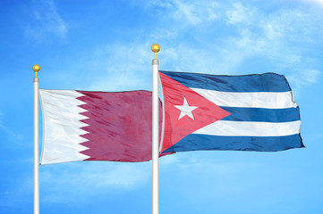 Qatar and Cuba two flags on flagpoles and blue cloudy sky
