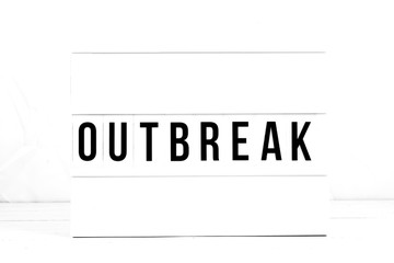 Outbreak flat lay on a white background. Public Health Awareness on a Vintage Retro quote board