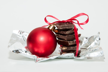 new year composition with chocolate, red ball and ribbon