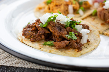 A closeup view of a carne asada taco, in a restaurant or kitchen setting.