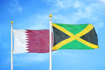 Qatar and Jamaica two flags on flagpoles and blue cloudy sky