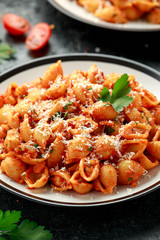 Conchiglie rigate pasta with chickpeas in tomato sauce with parmesan cheese. Healthy vegan food.