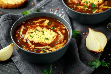 French onion soup with cheese toast on rustic background