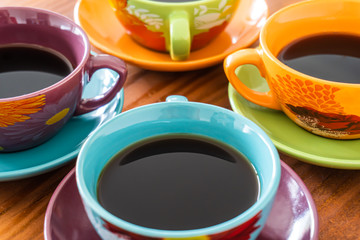 Tazas de colores de café sobre mesa de madera