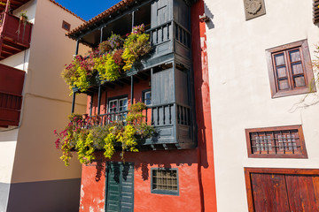 Fototapeta na wymiar Famous ancient colorful balconies decorated with flowers. Santa Cruz - capital city of the island of La Palma, Canary Islands, Spain.