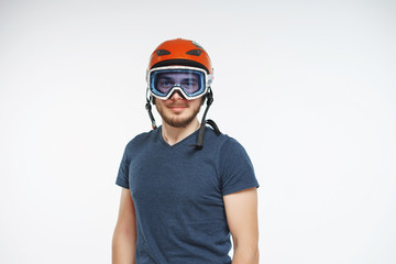 Skier in helmet and glasses in studio with white background