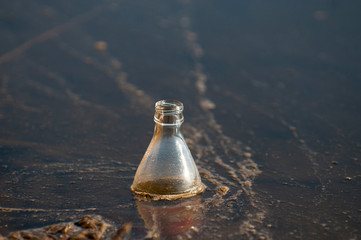 Old plastic bottle floating in water. Environmental pollution. The fight against economic crimes