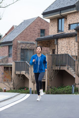 Fototapeta na wymiar A young Asian woman jogging in the community