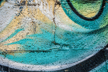 Graffiti close-up on concrete block wall texture. Street art background. Green, yellow and white.