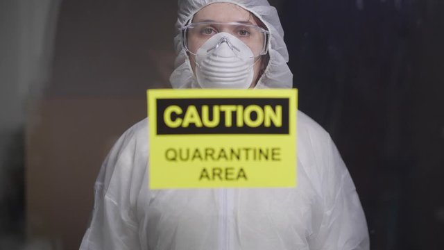 woman in protective suit in quarantine zone. Coronovirus and isolation concept