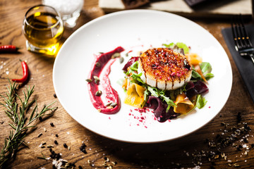 Grilled goat cheese salad served on a plate in restaurant