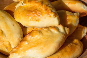 Baked cakes. Yeast baking. Pies with meat, cabbage and mushrooms. Homemade food. Slavic cuisine. Delicious pastries. Ruddy snack. Flour product. Bake in the oven. Junk food.