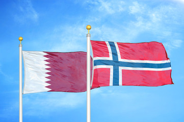 Qatar and Norway two flags on flagpoles and blue cloudy sky