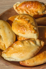 Baked cakes. Yeast baking. Pies with meat, cabbage and mushrooms. Homemade food. Slavic cuisine. Delicious pastries. Ruddy snack. Flour product. Bake in the oven. Junk food.